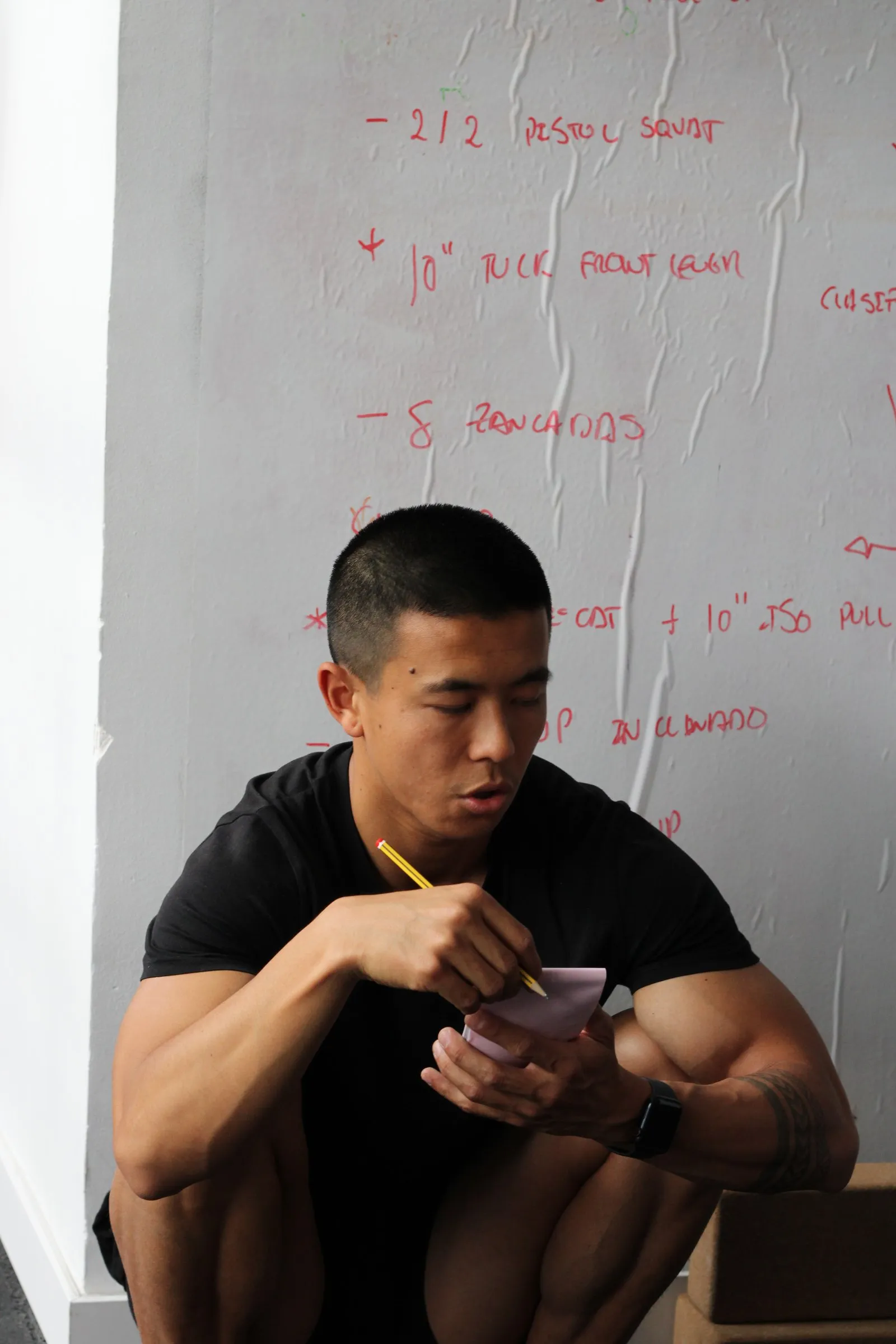 Xian Lai Jin, entrenador de Airgym, tomando notas delante de una pizarra con un plan de entrenamiento