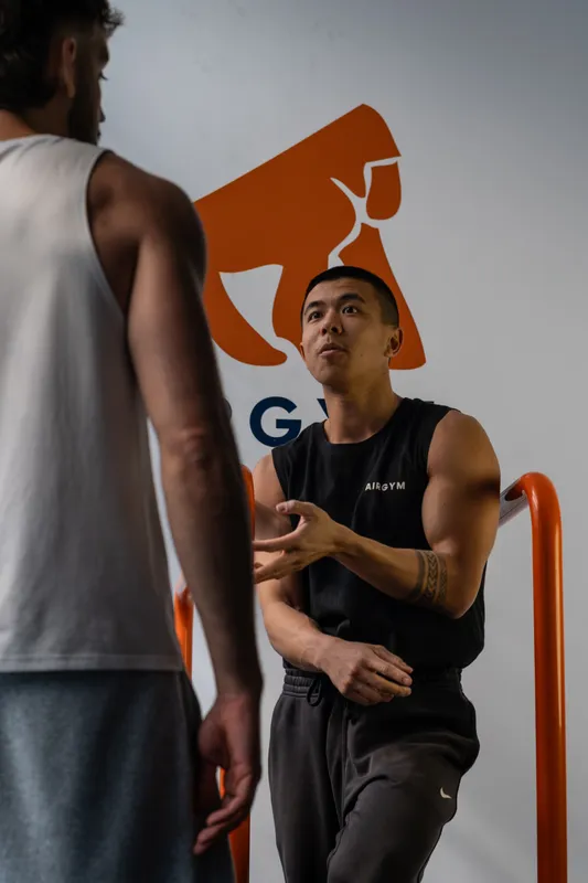 Xian Lai Jin explicando un ejercicio a un alumno en Airgym